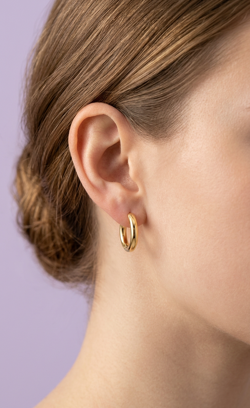 Kids hypoallergenic gold hoop earring worn by a girl with a blurred background