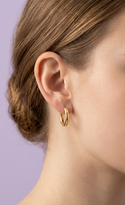 Kids hypoallergenic gold hoop earring worn by a girl with a blurred background