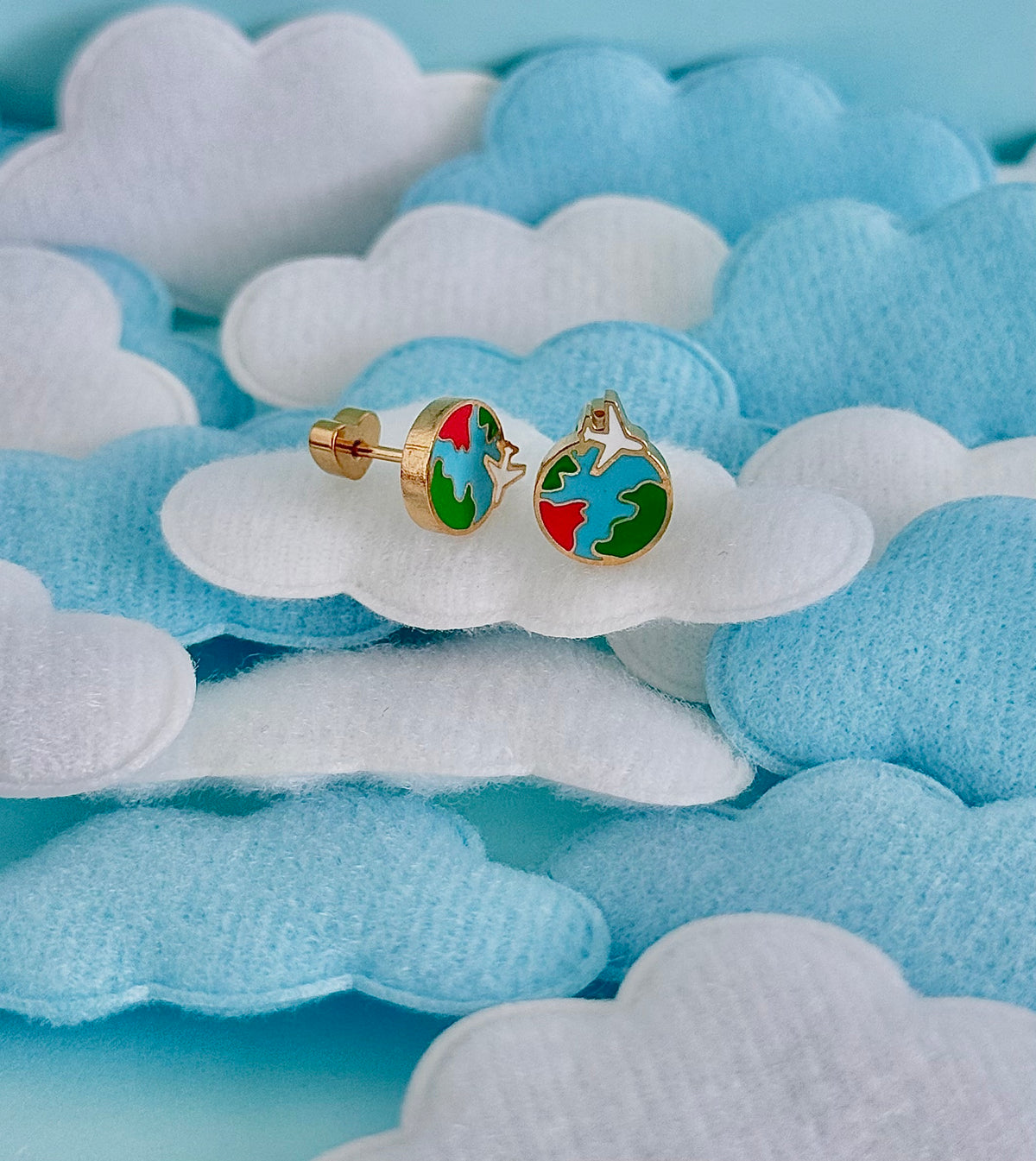 A pair of kids small hypoallergenic round gold-tone heart screwback stud earrings with colorful enamel details, displayed on a white and blue cloud background from the Pierced Peanut.