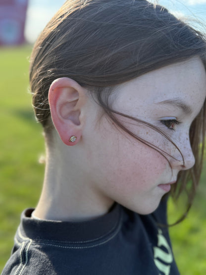 Side view photo of a young girl wearing hypoallergenic silver planet shaped screwback stud earrings with gemstones from the Pierced Peanut.