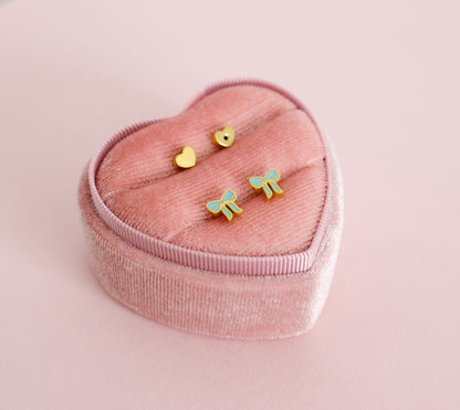 hypoallergenic blue bow shaped screwback kids earrings displayed in a pink heart box