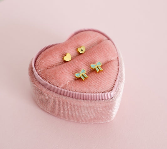 hypoallergenic blue bow shaped screwback kids earrings displayed in a pink heart box