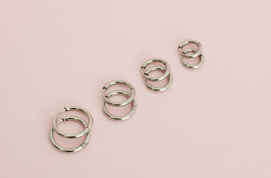Four pairs of kids hypoallergenic silver huggie hoop earrings in varying sizes. Earrings are from The Pierced Peanut Earring Co in New Zealand, NZ.