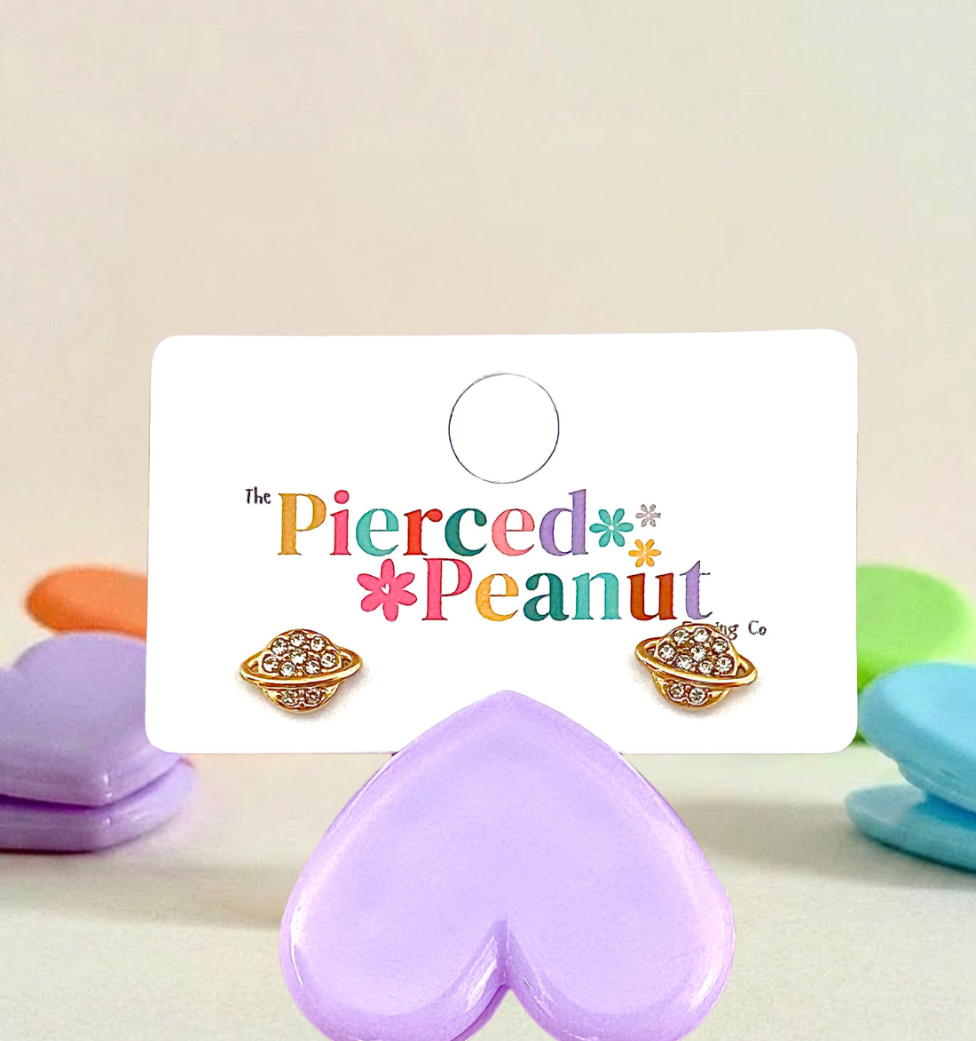 Hypoallergenic planet shaped screwback earrings on a 'The Pierced Peanut' branded card with colorful text.