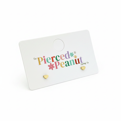 Dainty heart stud earrings on white background